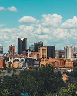 View of St. Paul city skyline with iconic buildings, greenery, and the Mississippi River under a bright sky, displayed on a watch face