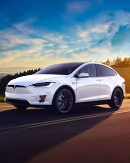 Tesla Model X Horizon watch face featuring a stunning white Tesla Model X driving on a scenic road at sunrise.