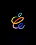 Apple-inspired watch face featuring a vibrant script logo in rainbow colors on a black background