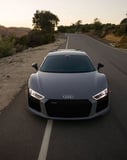 Audi R8 parked on a winding road at sunset, featured on a watch face