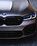 Close-up of BMW M5 front grille and LED headlights, featured on a watch face