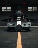 A matte black Bugatti Chiron with a white stripe, parked in front of a fighter jet in a hangar, featured on a watch face.