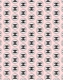 Coco Chanel repeated "CC" logo pattern on a soft pink background, displayed on a watch face