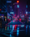 Nighttime view of a Tokyo street with neon lights reflecting on wet pavement, surrounded by urban buildings, displayed on a watch face