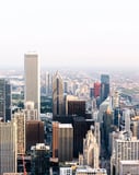 Aerial view of Chicago skyline showcasing skyscrapers and a sprawling urban landscape under a bright sky, displayed on a watch face