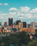 View of St. Paul city skyline with iconic buildings, greenery, and the Mississippi River under a bright sky, displayed on a watch face