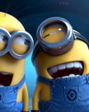 Two Minions smiling and laughing, dressed in blue overalls, set against a blue digital background, featured on a watch face.