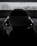 Front view of a luxury car in a blacked-out monochromatic style with sharp headlights, featured on a watch face.