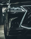 Close-up of a luxury SUV’s front headlights and grille, showcasing modern design and elegance, featured on a watch face.