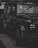 Mercedes-Benz G-Wagon in a sleek black finish with moody lighting, featured on a luxury watch face.
