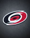 Carolina Hurricanes logo with a dark textured background, featuring a bold hurricane swirl, displayed on a watch face.