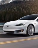 Tesla Scenic Drive watch face with a Tesla Model S driving through a forested road, paired with activity stats